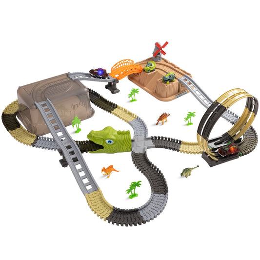 Children’s dinosaur-themed race track toy set featuring looping tracks, a green dinosaur tunnel, small toy cars, plastic palm trees, and dinosaur figurines. The playset includes bridges, ramps, and a windmill.