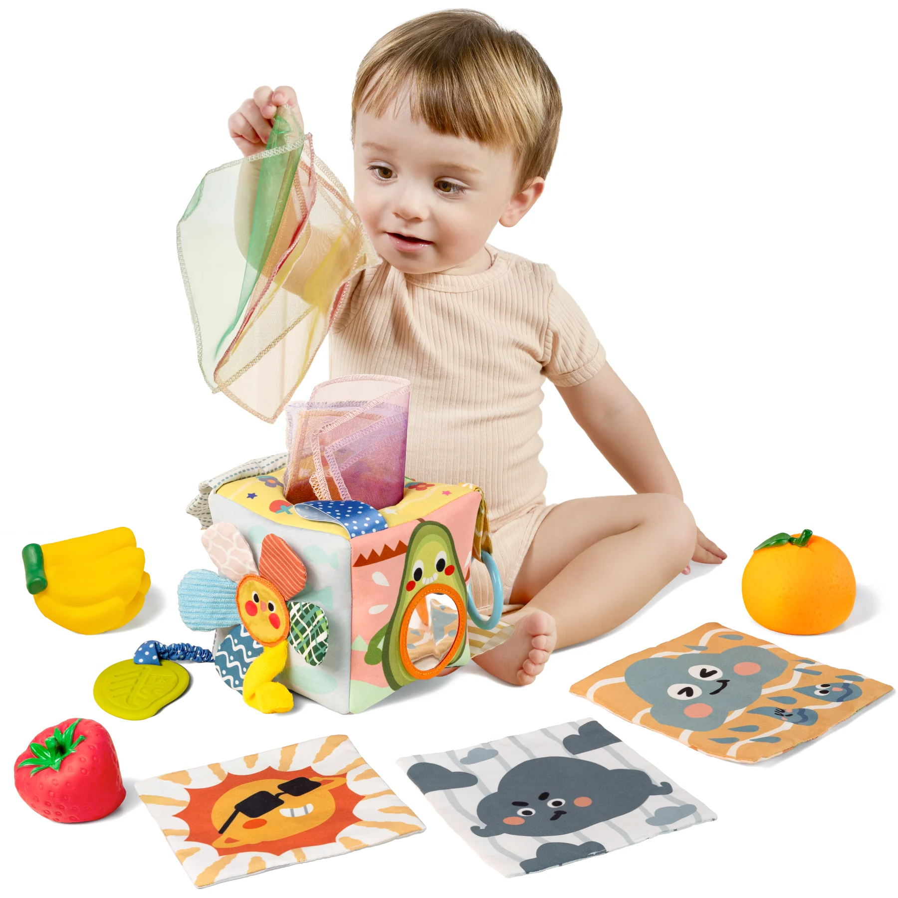 Baby playing with a Montessori tissue box toy, surrounded by soft fruit toys and animal-themed cloth cards, ideal for sensory development and early learning.