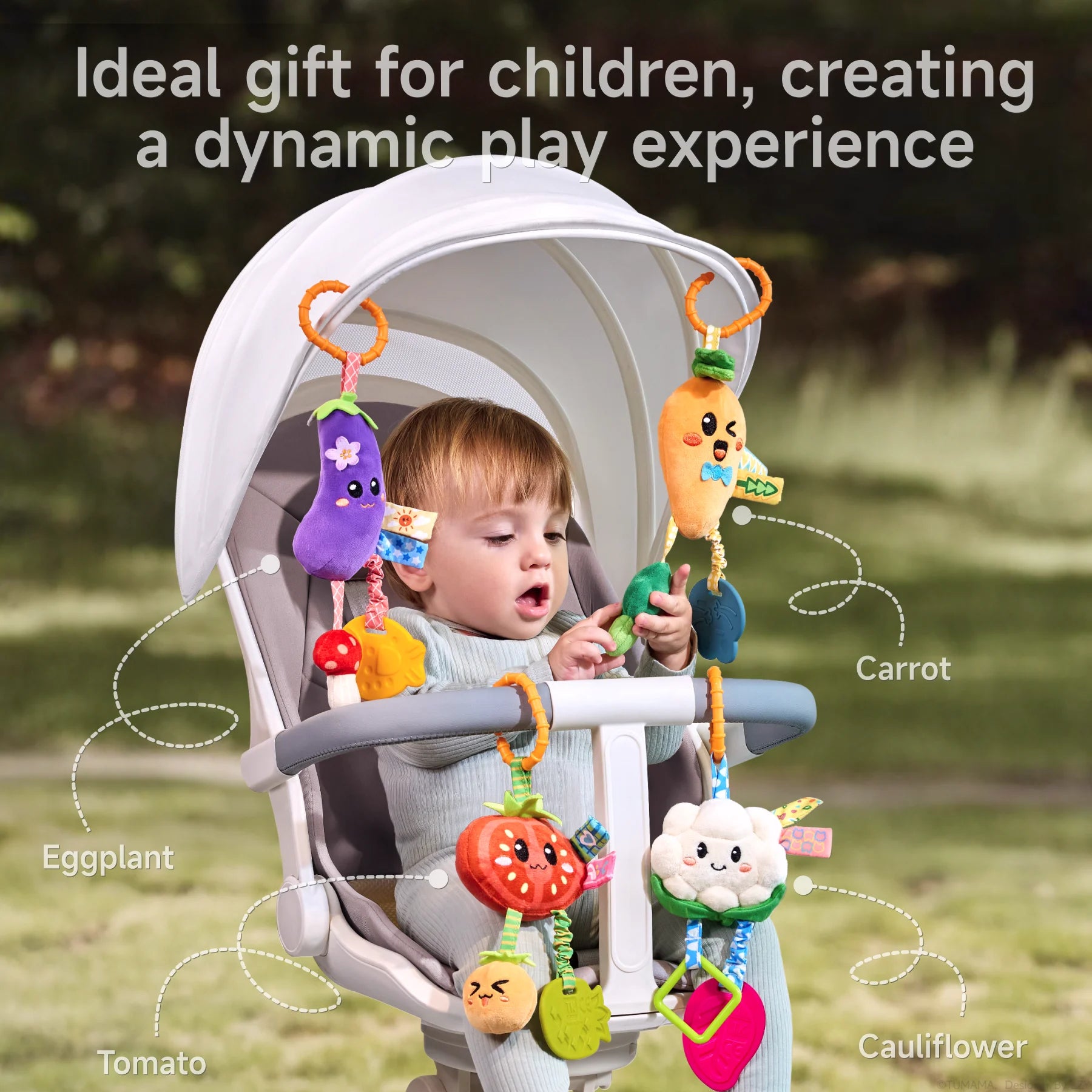 A baby seated in a stroller playing with colorful hanging toys, including eggplant, carrot, tomato, and cauliflower characters. Each toy features sensory elements like teethers, rattles, and crinkle textures, providing a dynamic play and learning experience.