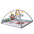 Colorful baby play gym with soft padded mat, two grey arches, and five hanging plush rattles including a hedgehog with mirror, cat, cow, lamb, and elephant. Side cloth book panel with colorful illustrations adds interactive play.