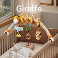 A baby lying in a crib, smiling and playing with a giraffe-themed arch toy. The toy features a plush giraffe, elephant teether, tree bead rattle, and lion BB device, securely attached to the crib for interactive playtime.